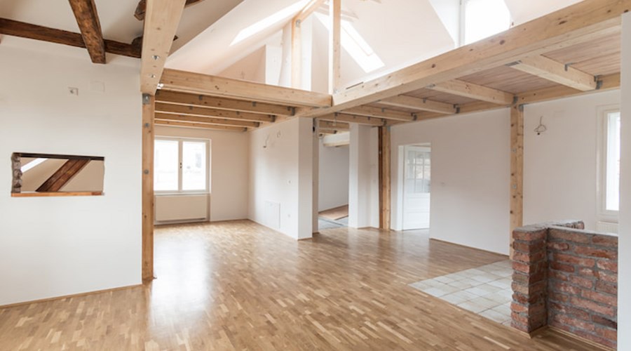 Færdig renoveret loftsetage med synlige spær og nyt parketgulv — eksempel på Bjerre Entreprise-projekt